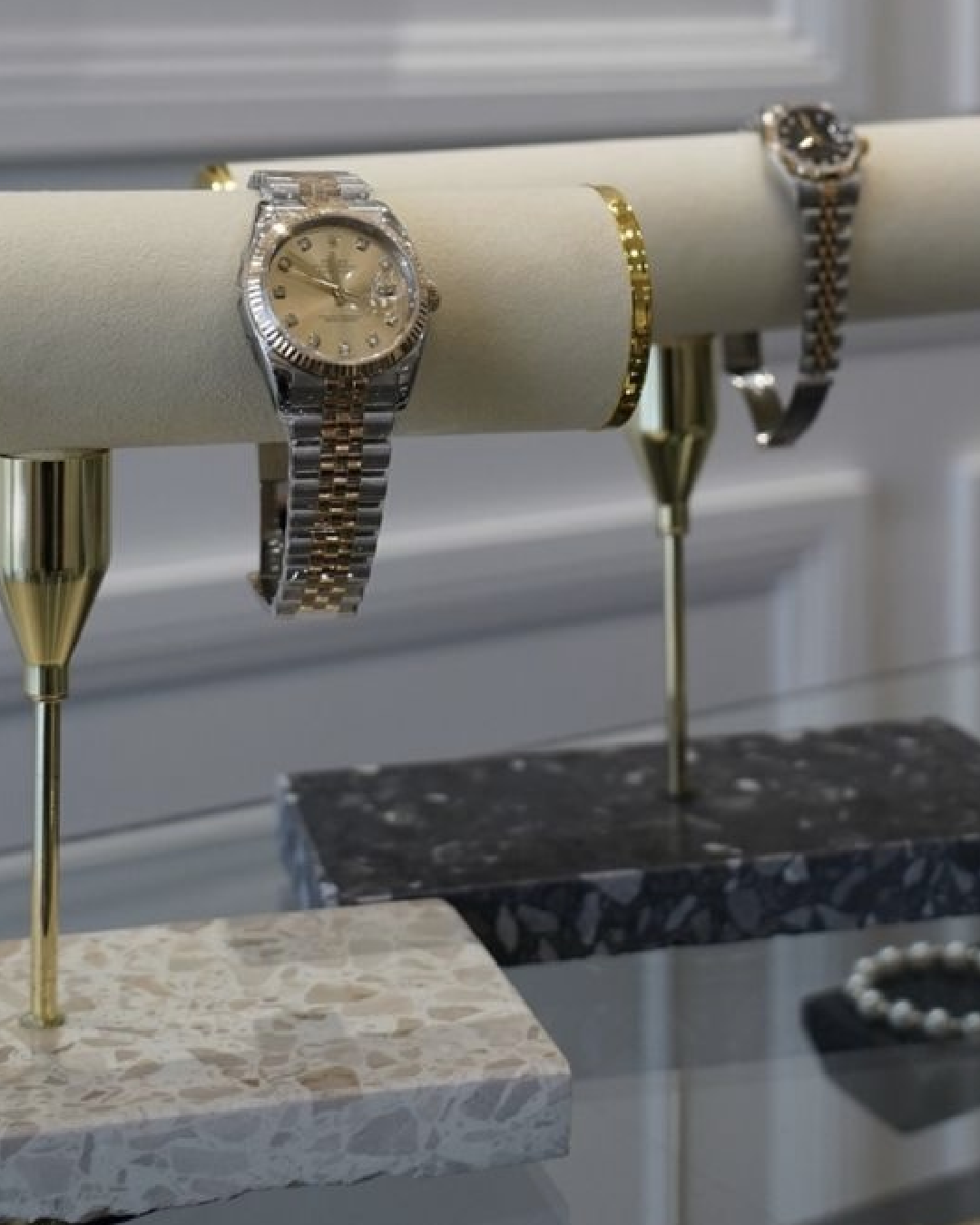Luxury watches displayed on Insieme’s Watch and Jewellery stands with terrazzo bases and velvet cushions.