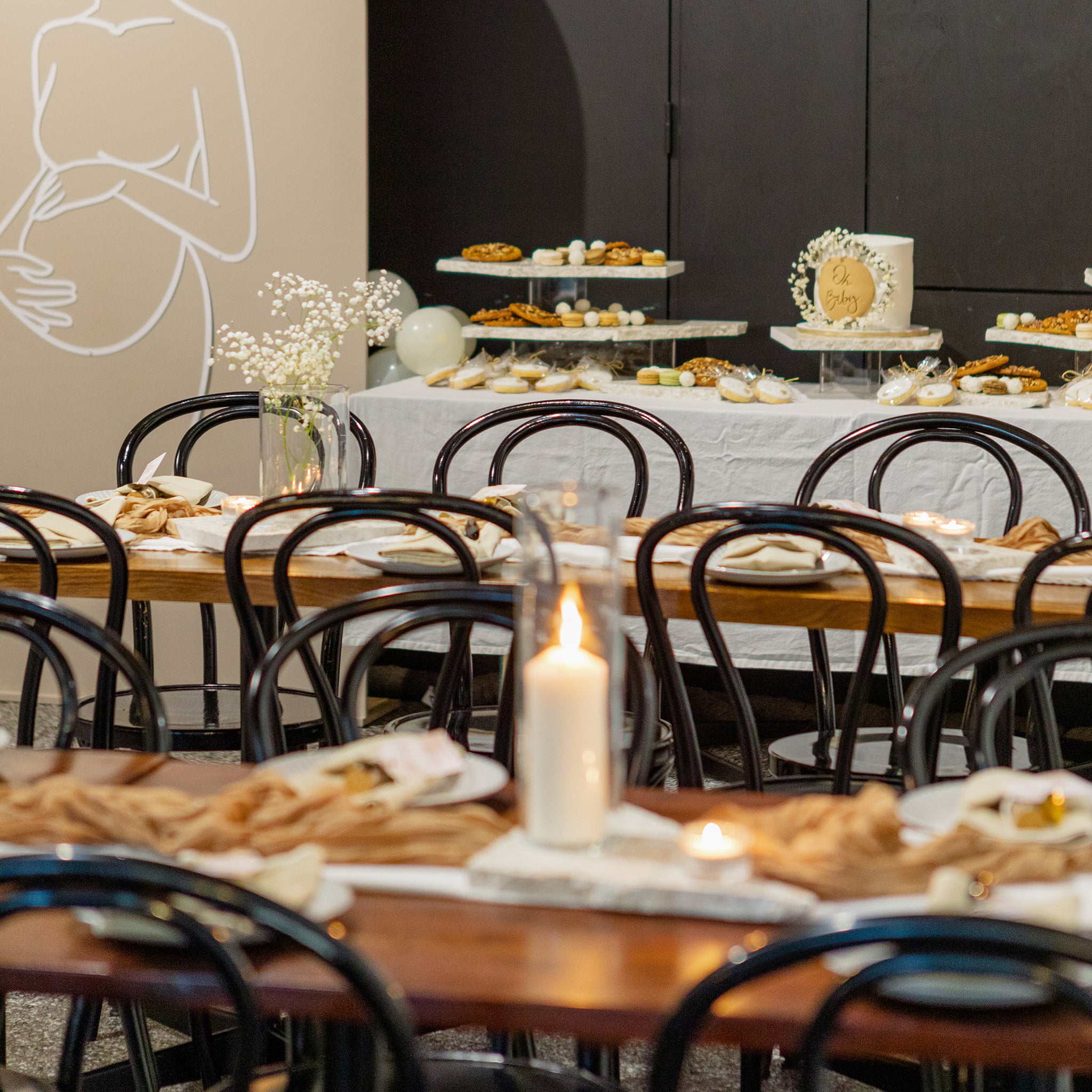 Baby shower and milestone celebration setup featuring Insieme Homewares terrazzo platters on long tables and a dessert station — styled with soft florals, warm candlelight, and neutral-toned decor.