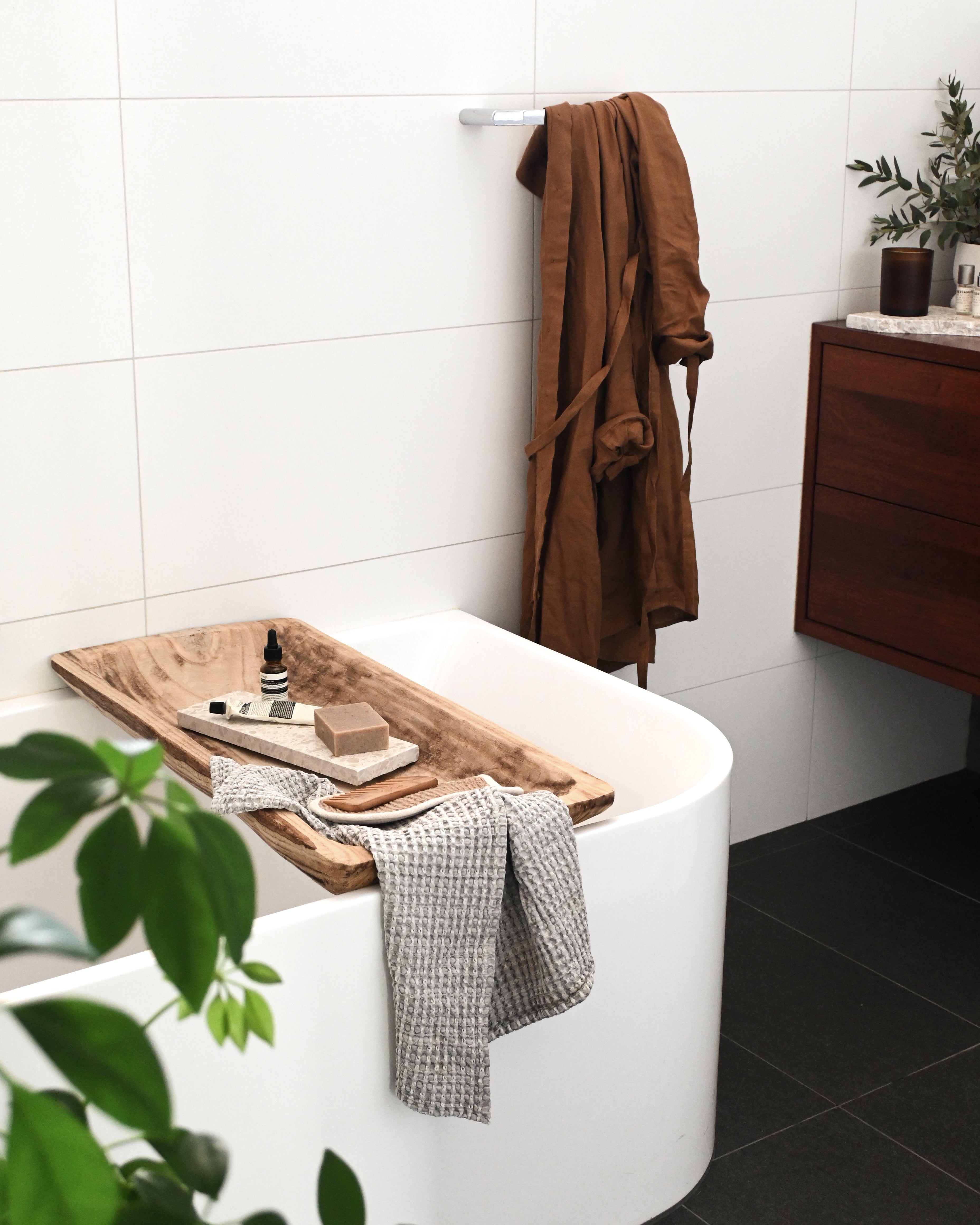 Insieme’s Medium Dessert Dish used as a bath tray, holding soap and skincare over a bath.