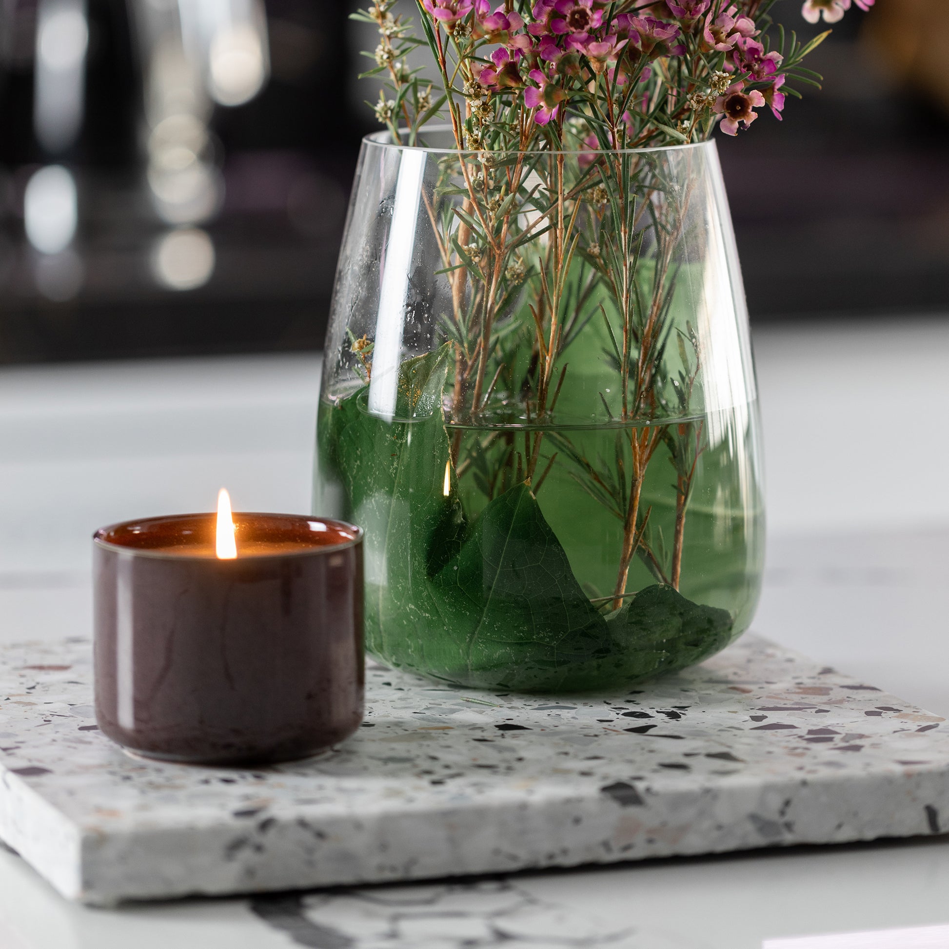 Home Sweet Home Set in Autunno – warm-toned terrazzo base with a clear vase and cherry red candle, adding a cosy, earthy touch to styled spaces.