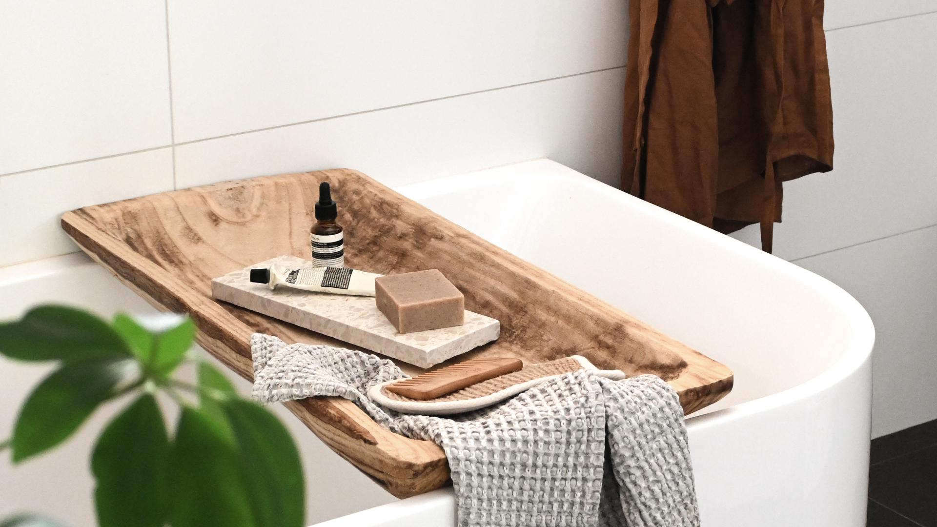 Insieme Homewares terrazzo dish styled in a bathroom on a wooden bath caddy with natural soap, Aesop skincare, and a textured towel — showcasing the versatility of handcrafted stoneware for spa-like rituals and everyday self-care.
