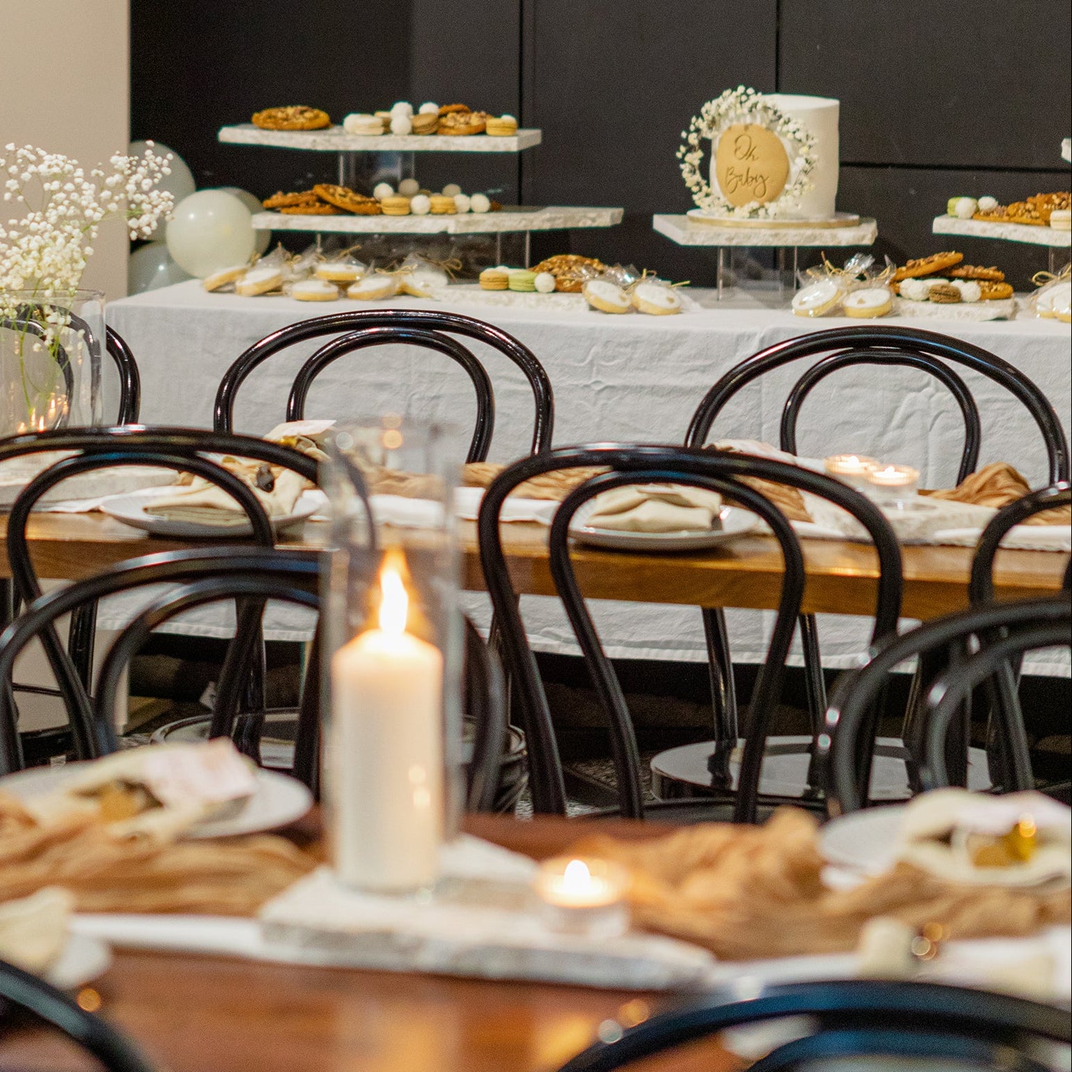 Baby shower and milestone celebration setup featuring Insieme Homewares terrazzo platters on long tables and a dessert station — styled with soft florals, warm candlelight, and neutral-toned decor.