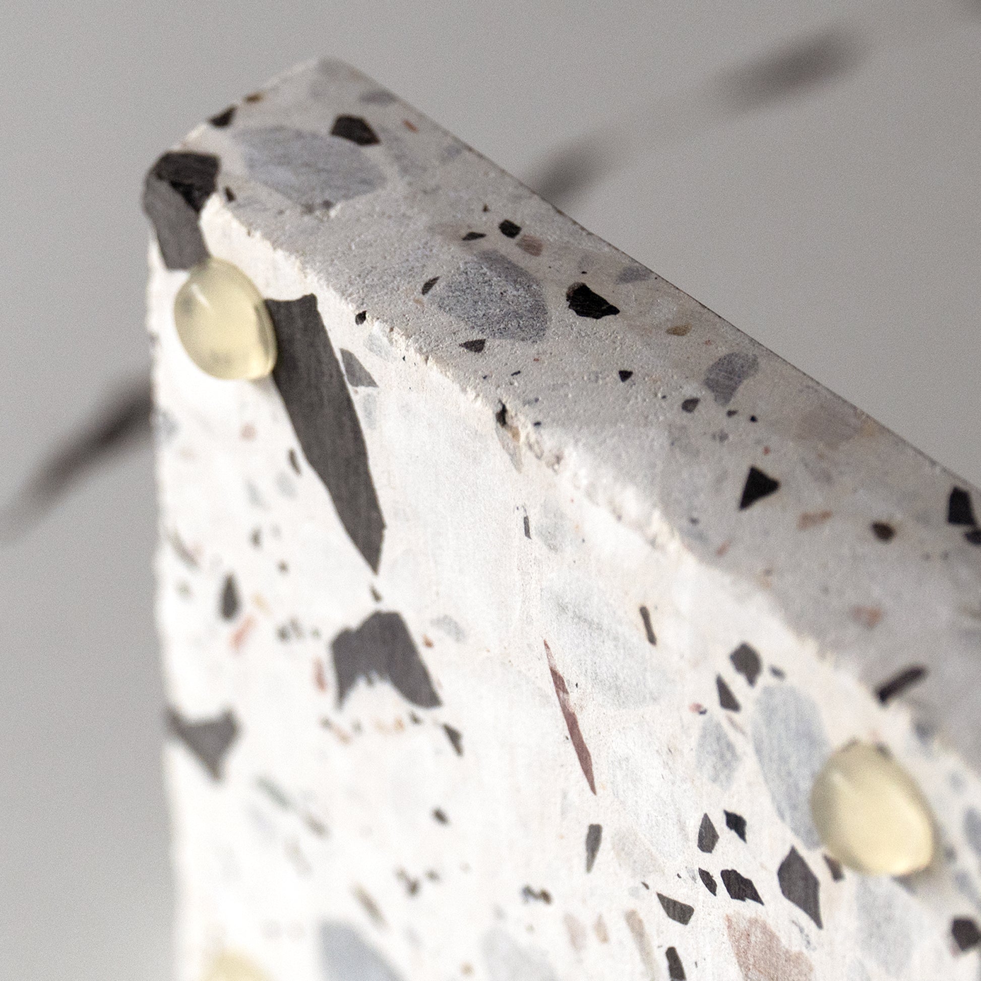 Close-up of terrazzo platter feet detailing on Insieme Homewares piece, showcasing stable elevation and natural surface texture.