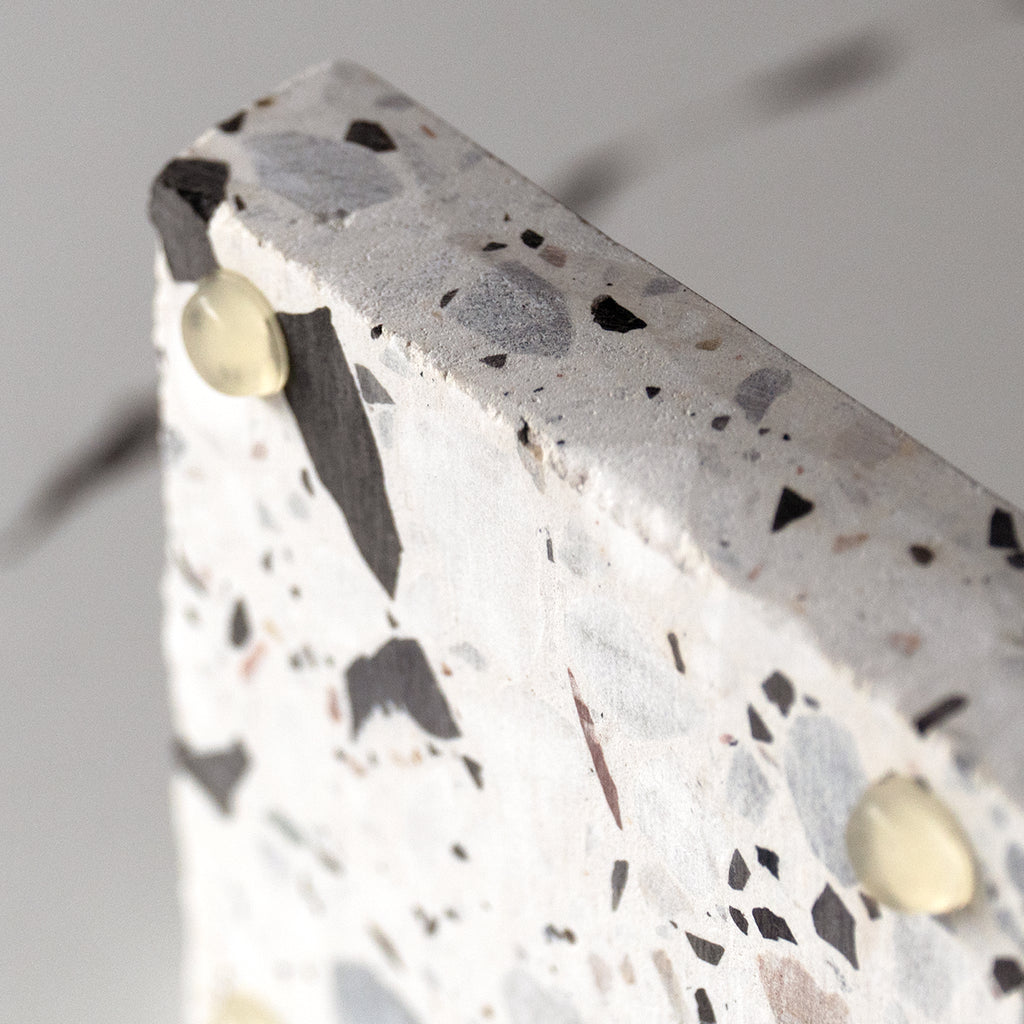 Close-up of terrazzo platter feet detailing on Insieme Homewares piece, showcasing stable elevation and natural surface texture.