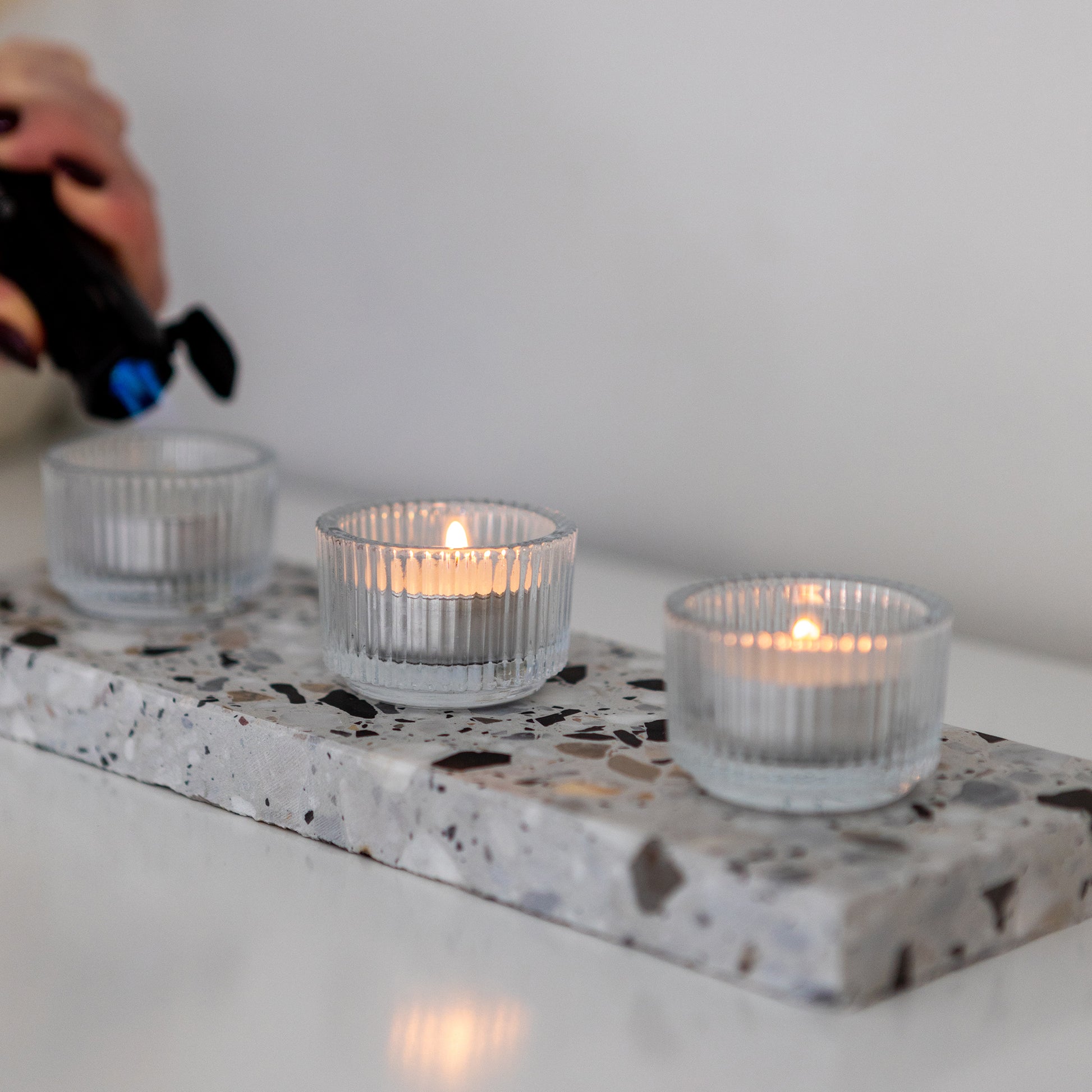 Insieme Homewares terrazzo base in Estate styled with ribbed glass tealight holders — a minimalist candlelight setup for ambient home styling and thoughtful entertaining.