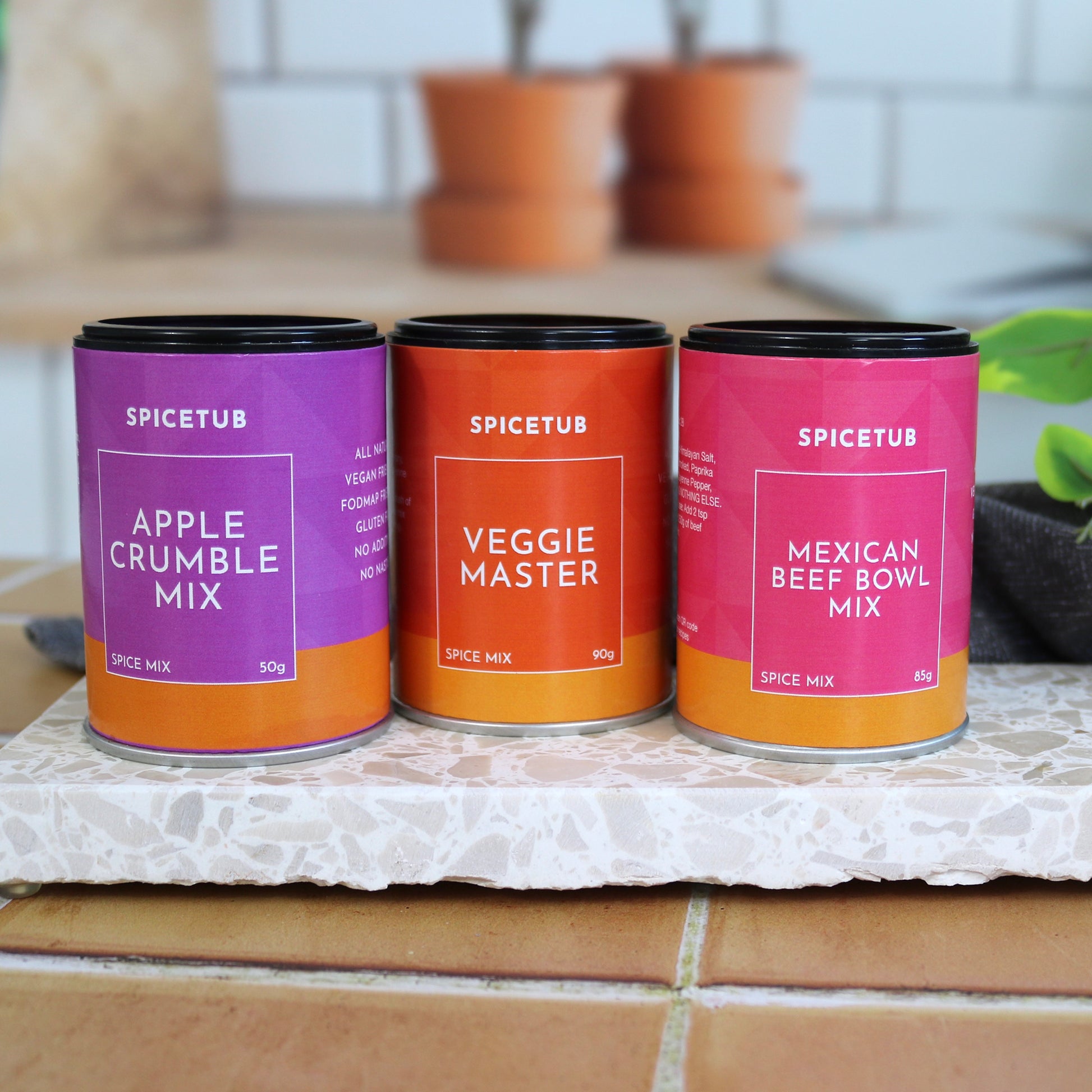 Trio of Spicetub spice blends arranged beside Insieme’s terrazzo platter, styled for a flavourful kitchen moment.