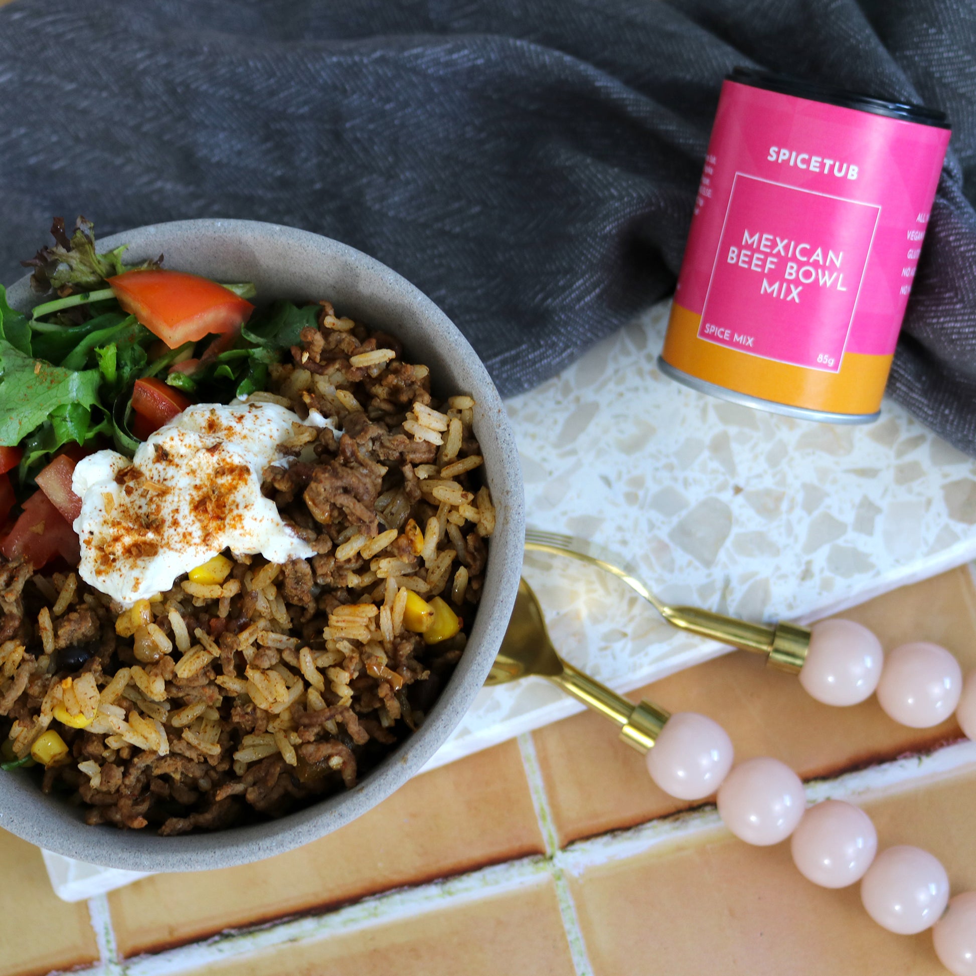 Spicetub’s Mexican Beef Bowl Mix styled beside a vibrant, ready-to-eat Mexican beef bowl on Insieme’s terrazzo platter—capturing bold flavour, colour, and everyday ease in one scene.