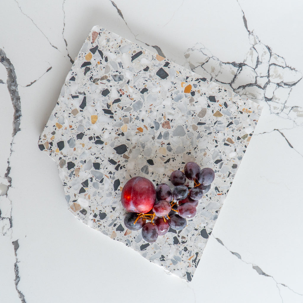 Flatlay of an Autunno organic terrazzo platter styled with fruit.