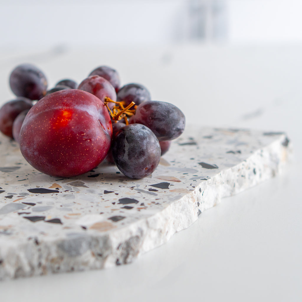 Detail shot of an Autunno organic terrazzo platter styled with fruit.
