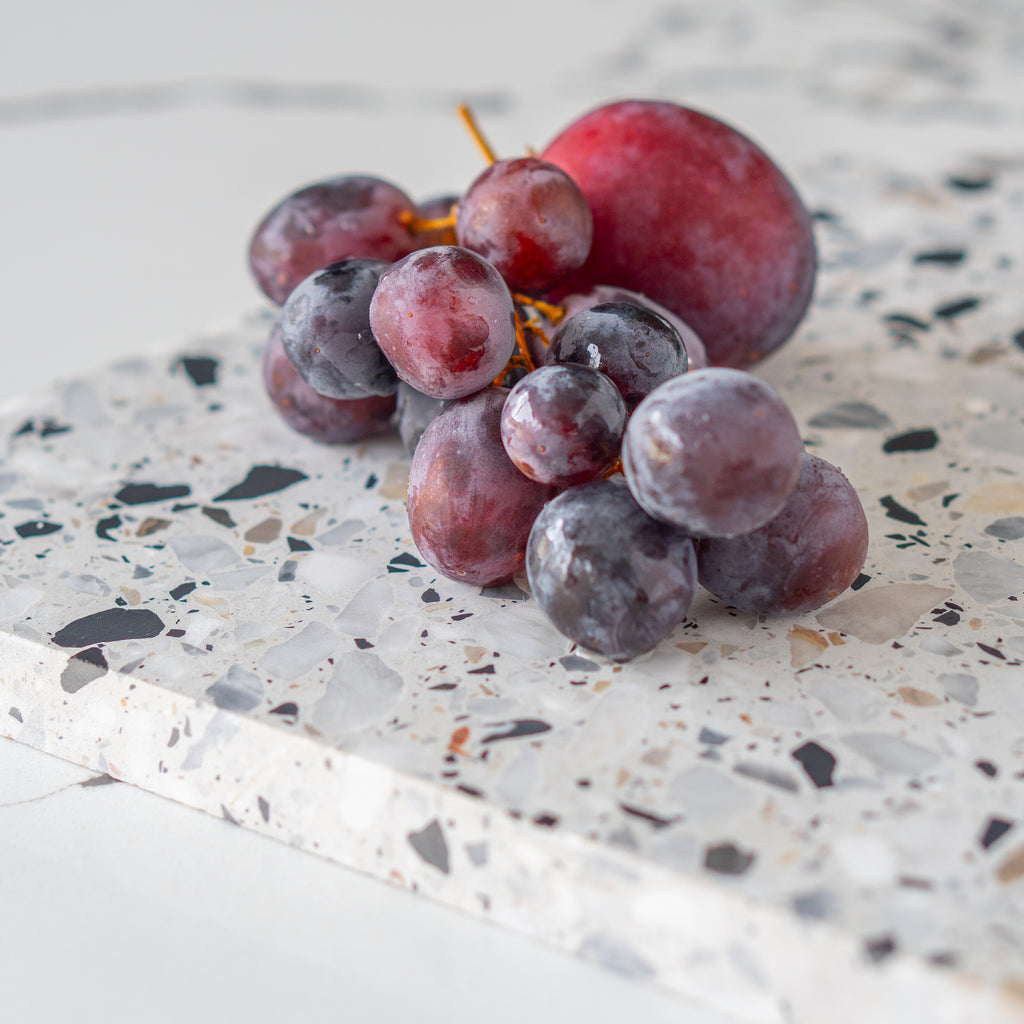Detail shot of an Autunno organic terrazzo platter styled with fruit.