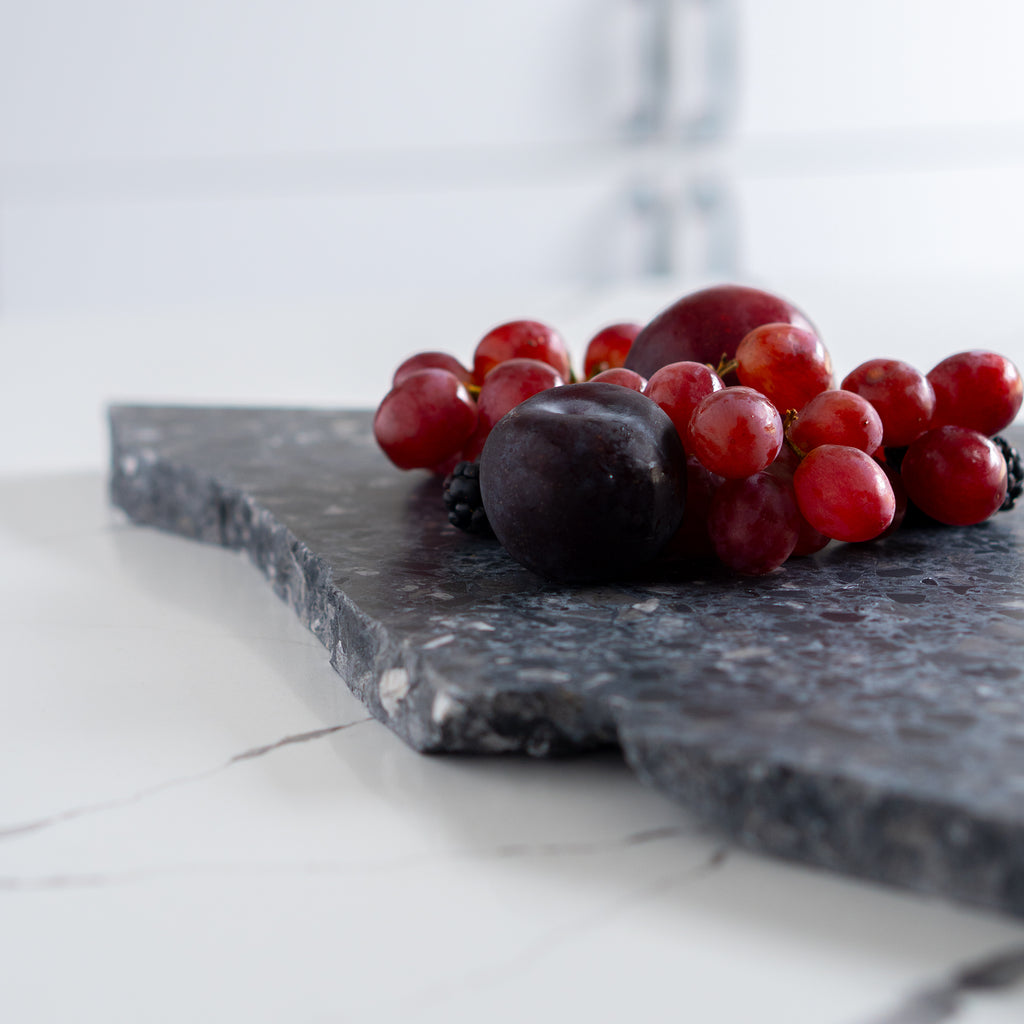 Organic terrazzo platter in Inverno styled with red grapes and plums.