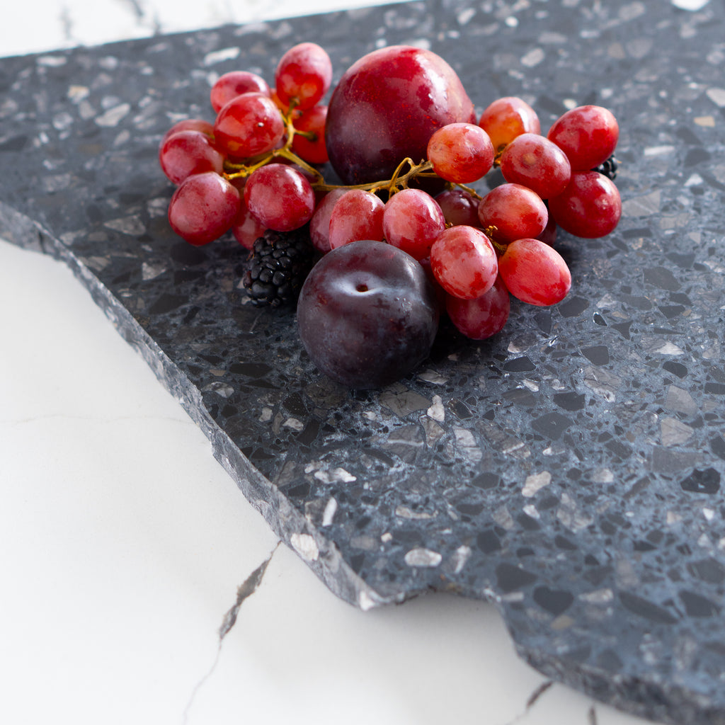Inverno terrazzo organic platter styled with fresh grapes, plum, and blackberry.